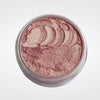 Caribe loose shimmer powder open jar showing radiant pink highlighter for face and body.