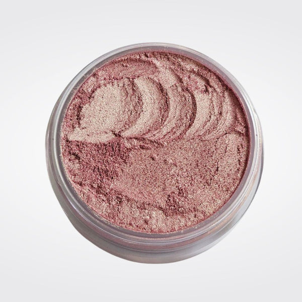 Caribe loose shimmer powder open jar showing radiant pink highlighter for face and body.