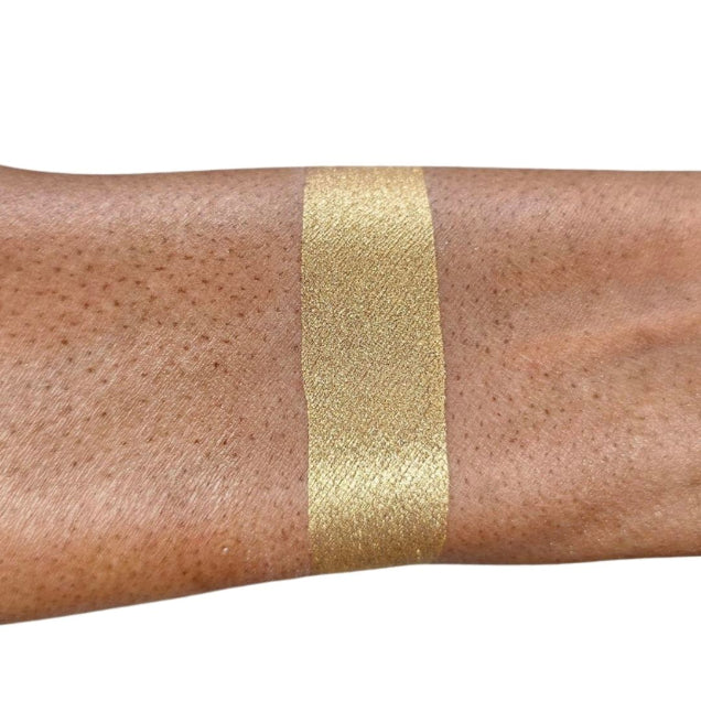 Caribe loose shimmer powder swatch showing radiant gold highlighter for face and body.