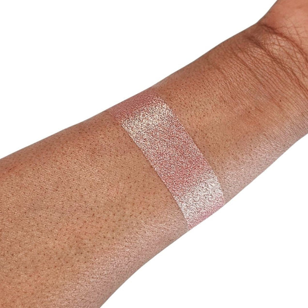 Caribe loose shimmer powder swatch showing radiant pink highlighter for face and body.