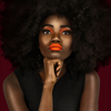 Close-up of model wearing bright orange shade with long-wear, smudge-resistant matte finish.