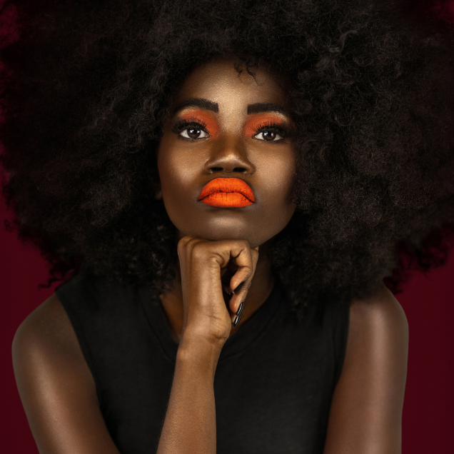 Close-up of model wearing bright orange shade with long-wear, smudge-resistant matte finish.