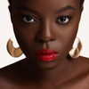 Orange red liquid matte lipstick shown on Model with high pigment and a smooth transfer-resistant finish designed to complement melanin-rich skin tones. 