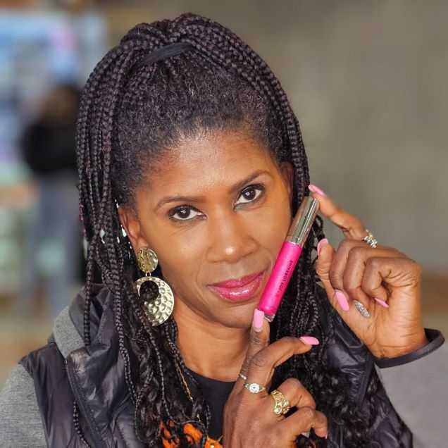 Model wearing pink vegan lip gloss with high-shine, non-sticky finish designed to complement melanin-rich skin tones.