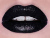 Lip with black liquid lipstick over matte black lipstick for bold statement look.