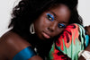 Model wearing deep cocoa powder foundation in Trinidad shade for buildable matte coverage.
