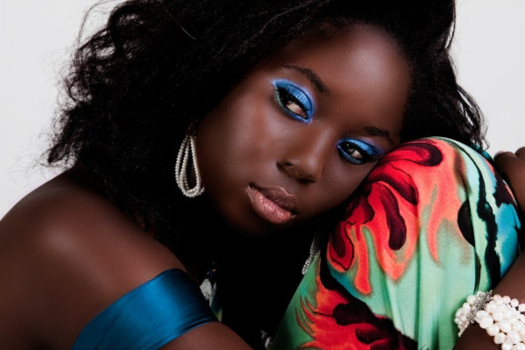 Model wearing deep cocoa powder foundation in Trinidad shade for buildable matte coverage.
