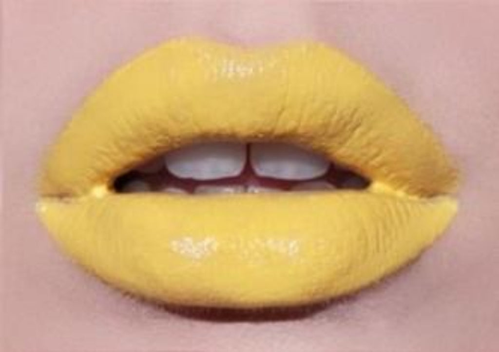 Lip swatch showing bold yellow liquid lipstick over matte yellow lipstick for editorial makeup look.