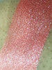 Swatch of Cherry Shimmer Eyeshadow; a loose eyeshadow with microfine sparkling particles.